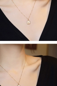 Détail d'un pendentif papillon doré sur nacre blanche avec une chaîne à billes raffinée
