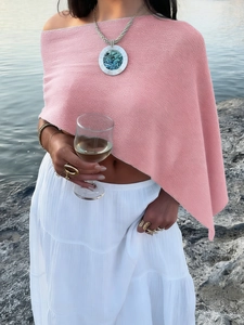 Detail of pink knitted poncho with round pendant necklace for summer vacation beach look