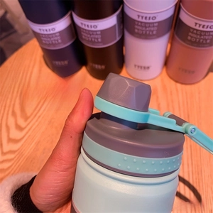 Detail of mint green insulated bottle cap with portable handle and secure screw lid