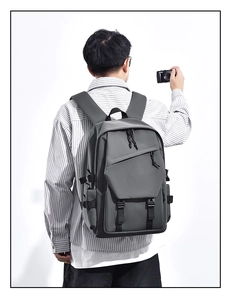Detailed back view of a dark grey nylon backpack with side buckles and adjustable straps