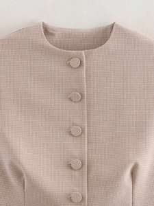 Dettaglio del gilet beige pied-de-poule con girocollo e bottoni rivestiti in tessuto