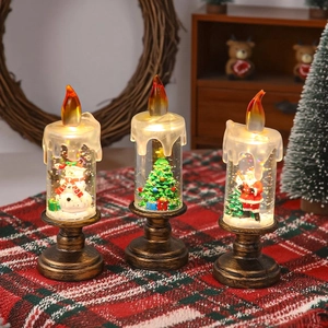 Trois lanternes bougies LED de Noël avec bonhomme de neige et Père Noël sur table festive