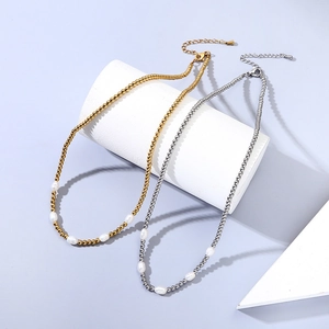 Dettaglio di collane a sfere 3mm oro e argento con cinque perle d'acqua dolce bianche