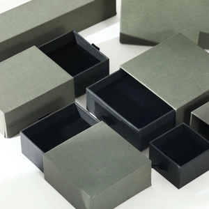 Close-up of minimalist green sliding drawer jewelry gift boxes with black velvet insert