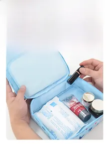 Détail d'une trousse à maquillage bleue montrant la poche en filet et l'intérieur
