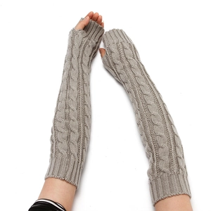 Detailed close-up of grey cable knit fingerless arm warmers with intricate textures