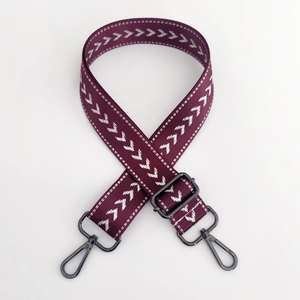 Detail of purple nylon strap with white arrow embroidery and black metal swivel hooks