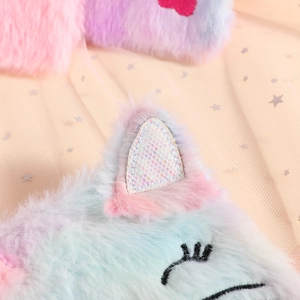 Macro detail of plush cat notebook featuring rainbow fur and sequin ear decoration