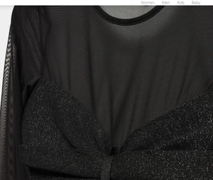 Détail des manches en résille et du tricot scintillant sur ce haut noir sexy