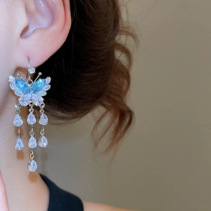 Detail of silver butterfly drop earrings with zircon tassel pendants on model