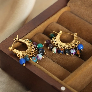 Boucles d'oreilles bohèmes dorées avec perles d'agate colorées dans un écrin de luxe
