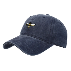 Navy washed cotton baseball cap with yellow bee embroidery in 3/4 side view