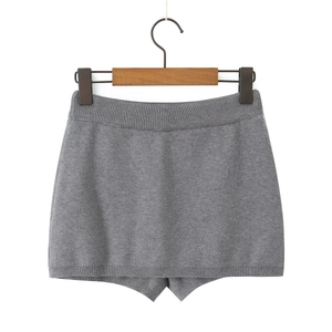 Detail of grey knitted skirt featuring elastic ribbed waistband and smooth texture