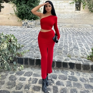 Detail of red off-shoulder slim dress with high slit and asymmetric sleeve design