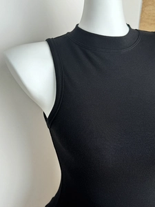 Nahaufnahme des schwarzen ärmellosen Stricktops mit Stehkragen und feiner Stoffstruktur