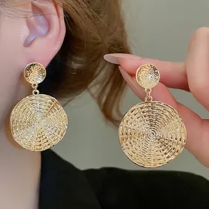 Golden round drop earrings with spiral woven texture for women in retro metallic style
