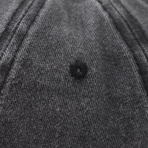 Detailed close-up of dark grey washed cotton baseball cap with reinforced stitching