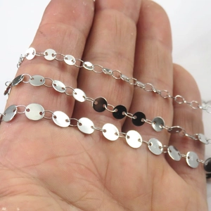 Polished silver stainless steel disc chain for DIY jewelry making held in hand for scale