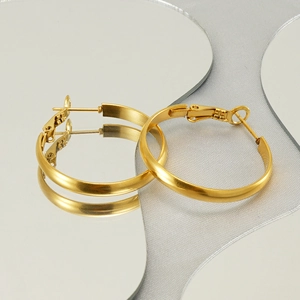 Chic golden matte round hoop earrings with snap closure on a heart-shaped mirror base