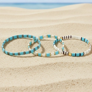 Bohemian beach style handmade elastic beaded bracelets set on sand background