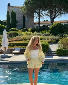 Detail of yellow and white striped linen two-piece set featuring shirt and shorts