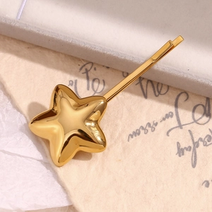 Detail shot of a 3D star-shaped hair clip in 18K gold plated stainless steel on paper