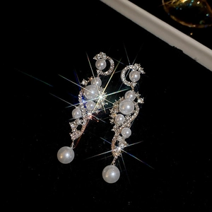 Macro detail of S-curved tassel earrings with sparkling rhinestones and white pearls