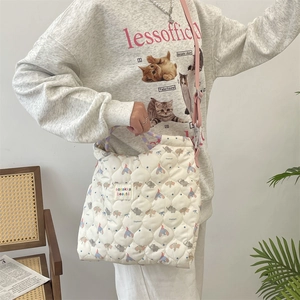 Détail du sac matelassé crème avec motif éléphant et bandoulière rose ajustable