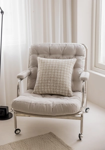 Close-up of beige cushion cover with houndstooth texture on modern metal frame chair
