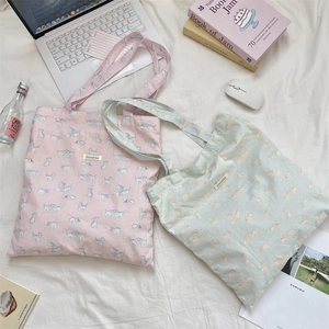 Lifestyle flat lay of canvas tote bags featuring cute cat prints and laptop accessories