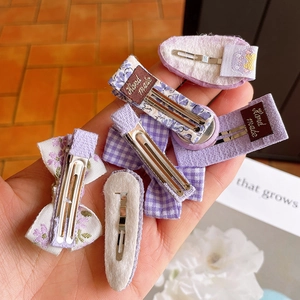 Detail of purple floral fabric hair clips with handmade labels and metal duckbill clips
