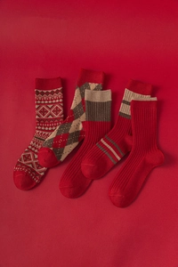 Détail de chaussettes de Noël en laine rouge avec flocons nordiques et motifs tricotés