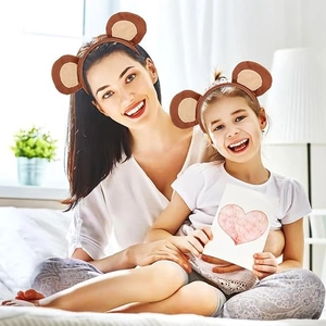 Brown plush monkey ear headbands worn by mother and child in a cozy home setting