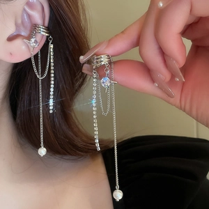Close-up of silver tassel ear cuff with rhinestones and pearl on a person's ear
