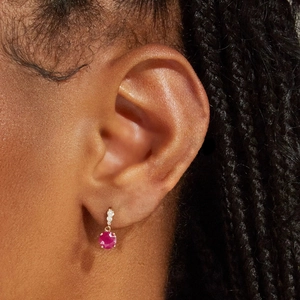 Close-up of vintage s925 silver earring with pink gemstone and gold finish on model