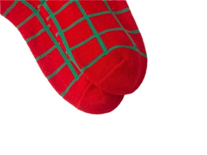 Close-up of red and green plaid patterns on knitted Christmas socks for children