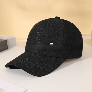 Detail of black baseball cap with rhinestone texture and golden metal logo emblem