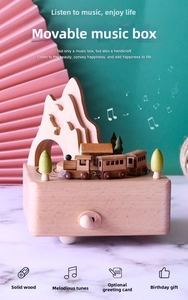 Detail of beech wood music box featuring a rotating train and mountain scenery