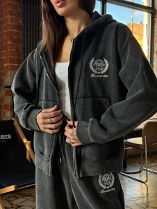 Détail du sweat à capuche délavé gris avec écusson de tennis vintage et couronne de laurier