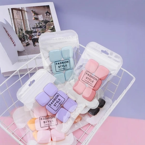 Square finger cushion puff set in pastel colors displayed in a white wire basket