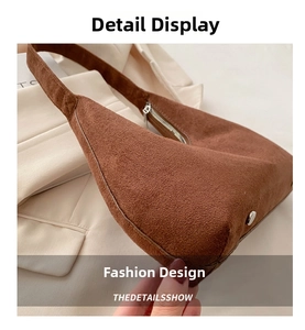 Close-up of brown suede hobo bag with silver zipper detail and side rivet accents