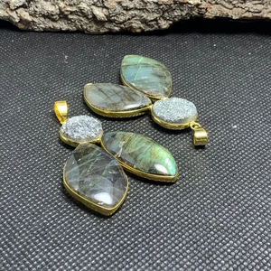 Detailed view of leaf-shaped labradorite pendants with blue iridescent flash and gold plating