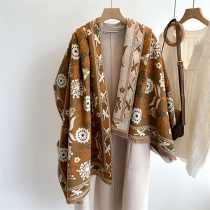 Detail of brown floral cashmere-feel scarf with tassels on a beige coat