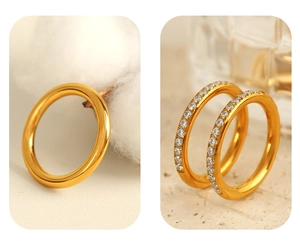 Close-up of golden minimalist metal rings featuring one plain band and one with small zircon