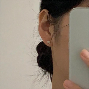 Minimalist 925 sterling silver star-shaped stud earring worn on the earlobe