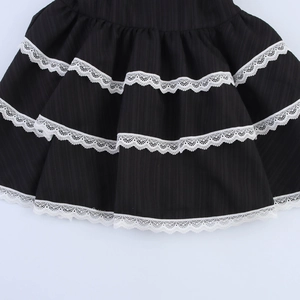 Robe noire sans manches avec volants superposés et bordure en dentelle blanche