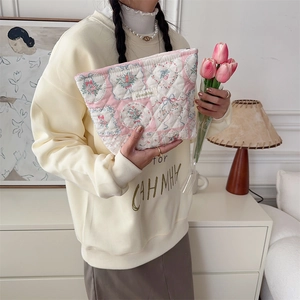 Quilted cosmetic bag featuring a pink floral pattern and Sezakka woven label detail