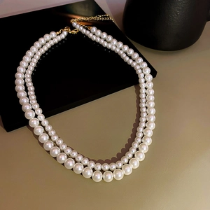 Dettaglio di elegante collana di perle barocche a due fili con chiusura dorata
