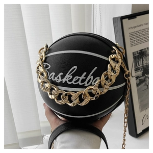 Close-up of black basketball shaped bag featuring silver lettering and gold chain strap
