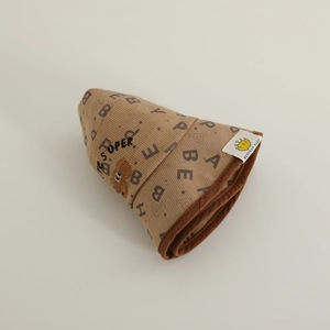Détail du chapeau cloche pour bébé en velours côtelé marron avec écusson ours mignon